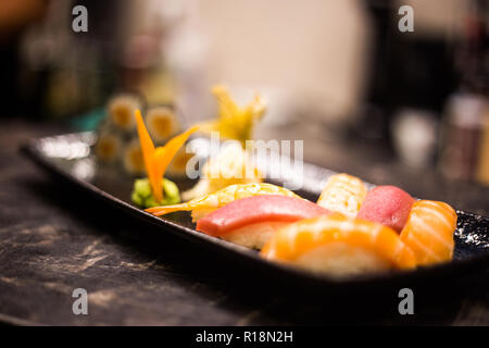 Sushi and rolls background, frame on black, top view. Colorful japanese restaurant food set, copy space Stock Photo