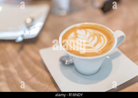 Digital tablet and cup of coffee on old wooden desk. Simple workspace or coffee break in morning/ selective focus Stock Photo