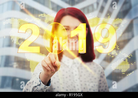 Smiling woman touching digital screen interface. Press on the golden 2019 icon with fingerprint scanning inside. Unlock the new year and start busines Stock Photo