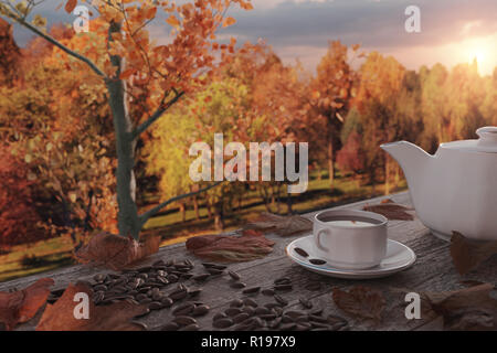 3d rendering of cup of coffee on wooden windowsill with leaves in front of forest in beautiful autumn sunlight Stock Photo