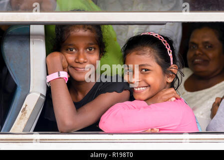 Kandy, Sri Lanka - August 19, 2017: Two smiling girls looking through window train at the Kandy's train station Stock Photo