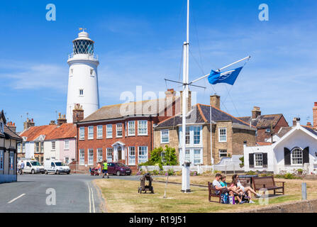 Southwold Suffolk Southwold Lighthouse and southwold houses People sat on a bench St James Green East Cliff Southwold Suffolk England UK GB Europe Stock Photo