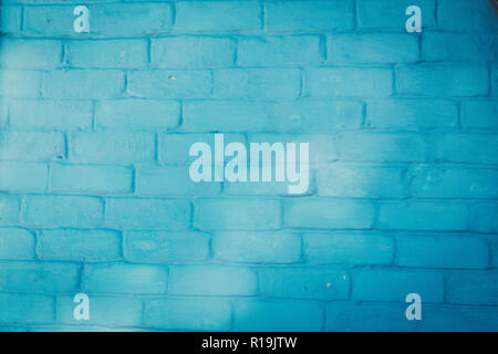 Abstract background texture of a wall. Plastered old brick wall, shabby uneven surface with whitewashing. Painted surface of the house wall. Stock Photo