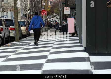 New York, NY, USA. 10 Nov., 2018. A stretch of a Brooklyn, New York sidewalk, has been transformed into a checkerboard of black and white squares across a patch of pavement outside a fancy new apartment building and store RISK Boutique and Gallery in the rapidly gentrified neighborhood of Bushwick. The Department of Transportation says people cannot legally paint sidewalks and unauthorized artistry typically receives a fine, with property owners usually get 30 days to remove their work before an official penalty follows. © 2018 G. Ronald Lopez/DigiPixsAgain.us/Alamy Live News Stock Photo