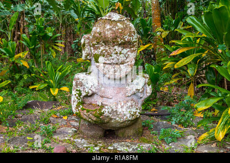 Smiling tiki. Carved stone tiki - Polynesian sacred idol statue hidden in jungle. Raivavae island, Astral islands (Tubuai), French Polynesia, Oceania
