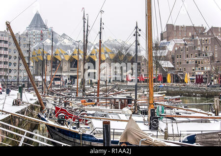 Rotterdam, The Netherlands, March 3, 2018: snow-covered historic barges in the Old Harbor, with the famous cube houses in the background, on a cold da Stock Photo