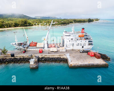Aerial view of Tubuai island and azure turquoise blue lagoon. Ship Tuhaa Pae IV unloading in the port of Mataura, Australs, French Polynesia, Oceania. Stock Photo