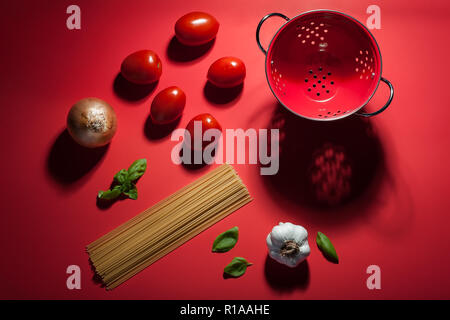 Seeing red - making pasta sauce. A deconstructed scene showing the ingredients used to make pasta and sauce. Stock Photo