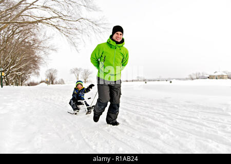A nice Father drag his boy in sled Stock Photo