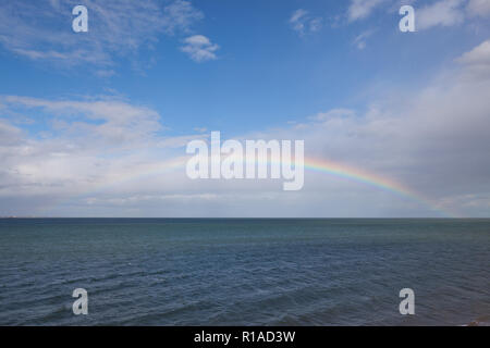 Rainbow seen out at sea. Stock Photo