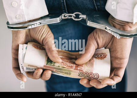 Hands in handcuffs with rubles. Concept on arrest for bribery Stock Photo