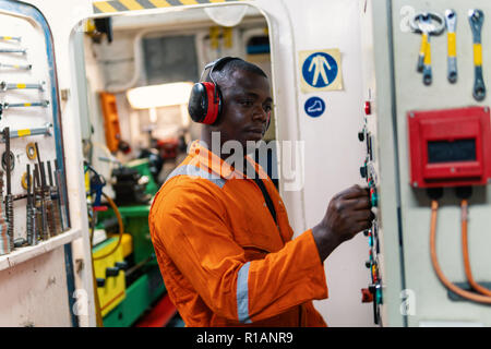 Marine engineer officer in engine control room ECR. Seamen's work. He starts or stops main engine of ship Stock Photo