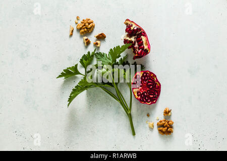 parsley, pomegranate seeds and walnuts scattered on the table. healthy super-food composition Stock Photo