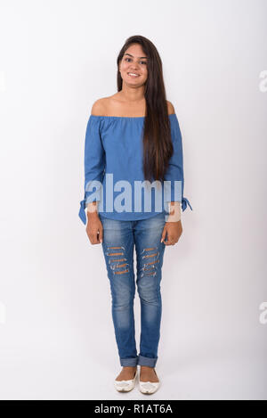 Full body shot of young happy Indian woman smiling and standing  Stock Photo