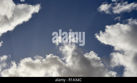 Sun flares from behind a cloud formation. Stock Photo