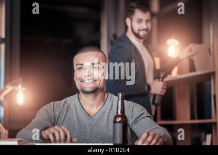 Positive delighted young man working in office Stock Photo