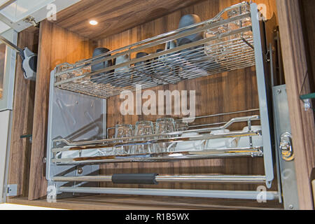 Interior design decor of kitchen in luxury apartment showing closeup detail of cupboard with swinging shelf