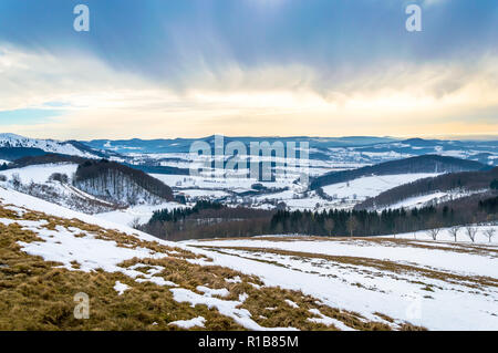 Winter landscape on Wasserkuppe with snow and dramatic sky in Rhoen Mountains, Germany Stock Photo