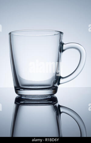transparent mug with reflection on a grey background Stock Photo