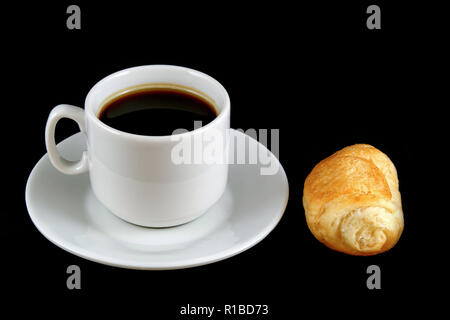 cup of coffee with a croissant isolated on a black background Stock Photo