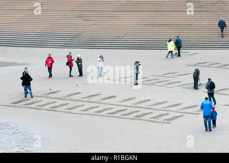 Blackpool, Lancashire, UK. 11th Nov, 2018. Remembrance Sunday.  People gather for a dawn remembrance in homage to the fallen soldiers of the Great World Wars. Sand sculptures are carved into the sand as shadows of the past to remember that all gave some & some gave all for our freedoms today. They are to be washed away as the tide comes as the crowd waves a collective goodbye. Credit: Cernan Elias/Alamy Live News Stock Photo