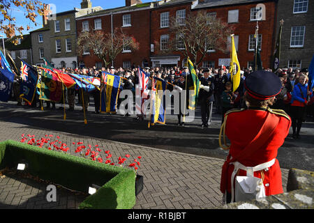 Bridport, Dorset, UK.  11th November 2018.  Standards are lowered during the last post at the Remembrance Sunday service at the war memorial outside St Mary's Church in South Street in Bridport.  The 2018 Remembrance Day falls on the 100th Anniversary of armistice day which marks the ending of World War One.  Picture Credit: Graham Hunt/Alamy Live News Stock Photo