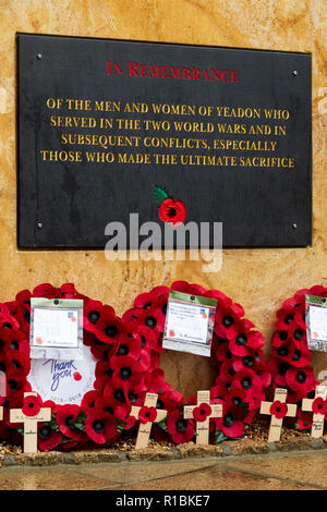 Yeadon, Leeds, West Yorkshire, UK 11th November, 2018. Close-up of the plaque inscription & crosses & poppy wreaths laid at the base of the new war memorial stone in front of Yeadon Methodist Church, on the anniversary of the end of the First World War. Ian Lamond/Alamy Live News Stock Photo