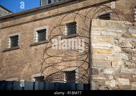 07 November 2018, Lower Saxony, Osnabrück: Barbed wire lines a wall of the Lingen correctional facility; Osnabrück department. Photo: Friso Gentsch/dpa Stock Photo