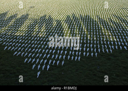 Queen Elizabeth Olympic Park, Stratford, London - 11 November  2018: Shadows of People seen ahead of the remembrance day memorial service at Elizabeth Olympic Park, London around 72,396 shrouded figures created by artist Rob Heard in memory of the fallen Commonwealth soldiers at Somme who have no known grave. The installation is made up of hand-sewing calico shrouds and bound over small figures by artist Rob Heard. Credit: David Mbiyu /Alamy Live News Stock Photo