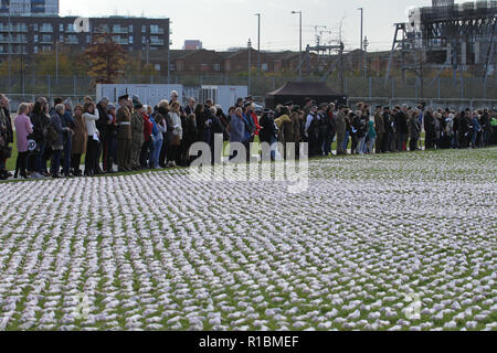 Queen Elizabeth Olympic Park, Stratford, London - 11 November  2018: People seen during the remembrance day memorial service at Elizabeth Olympic Park, London around 72,396 shrouded figures created by artist Rob Heard in memory of the fallen Commonwealth soldiers at Somme who have no known grave. The installation is made up of hand-sewing calico shrouds and bound over small figures by artist Rob Heard. Credit: David Mbiyu /Alamy Live News Stock Photo