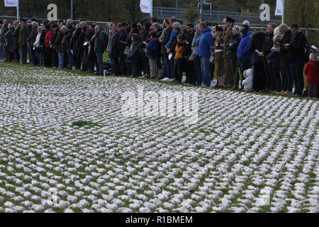 Queen Elizabeth Olympic Park, Stratford, London - 11 November  2018: People seen during the remembrance day memorial service at Elizabeth Olympic Park, London around 72,396 shrouded figures created by artist Rob Heard in memory of the fallen Commonwealth soldiers at Somme who have no known grave. The installation is made up of hand-sewing calico shrouds and bound over small figures by artist Rob Heard. Credit: David Mbiyu /Alamy Live News Stock Photo