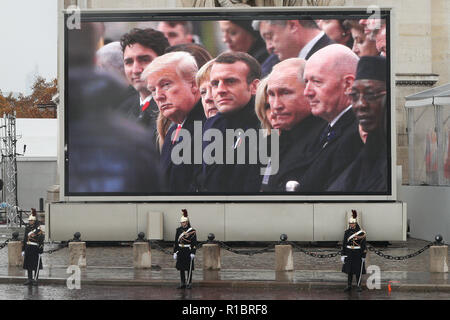 Paris, France. 11th Nov, 2018. A screen in front of the Arc de Triomphe shows the US President Donald Trump, German Chancellor Angela Merkel, French President Emmanuel Macron, Russian President Vladimir Putin and other politicians attend the ceremony to commemorate the 100th anniversary of the end of World War I in Paris, France, Nov. 11, 2018. Credit: Zheng Huansong/Xinhua/Alamy Live News