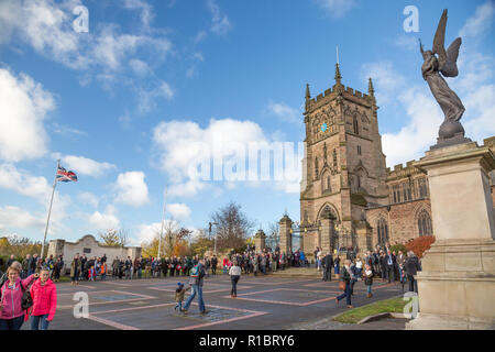 Kidderminster, UK. 11th November, 2018. With acts of remembrance taking place worldwide today, the people of Kidderminster come out in their hundreds to commemorate those who gave their lives for their country. On a gloriously sunny morning, crowds congregate at St Mary and All Saints Church, circling The Angel of Peace war memorial to pay their respects. Credit: Lee Hudson/Alamy Live News Stock Photo