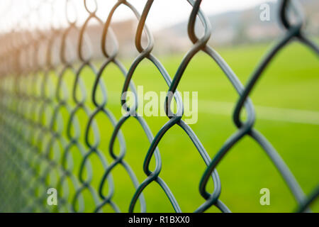 Wire fence or metal net on sunset and green background, pastel and vintage style. Stock Photo