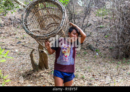 Don Khone, Laos - April 23, 2018: Local fisherman walking through the woods with a bamboo basket near the Mekong river Stock Photo