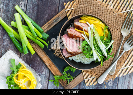 Hoisin duck with mango, spring onion, rocket lettuce salad and rice - top view Stock Photo