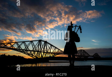 Piper Louise Marshall plays Battle's O'er, the traditional Scottish lament played at the end of battle, at dawn alongside the Forth Bridge at North Queensferry on the 100th anniversary of the signing of the Armistice which marked the end of the First World War. Stock Photo