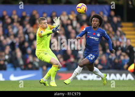 Everton goalkeeper Jordan Pickford (left) and Chelsea's Willian battle for the ball during the Premier League match at Stamford Bridge, London. Stock Photo