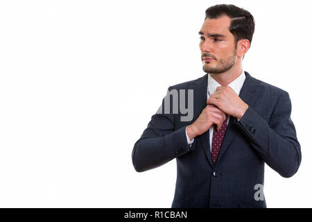 Studio shot of young handsome businessman thinking and looking a Stock Photo