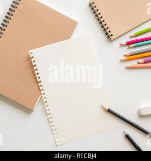 blank paper with spiral notebook, pencil, eraser and color pencil on white background. Empty Space for your Text. Stock Photo