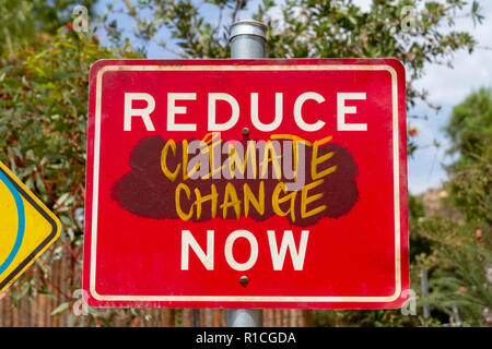 Road traffic sign adapted with environmentally friendly message ('Reduce Speed Now' to 'Reduce Climate Change Now', San Diego Zoo Safari Park, CA, USA Stock Photo