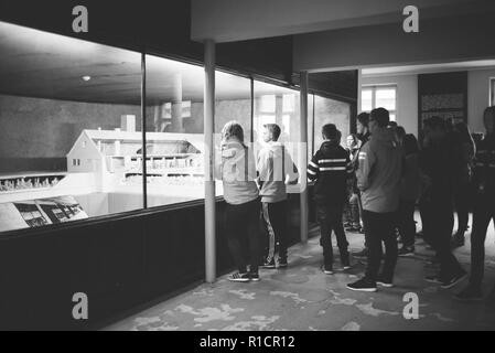 Auschwitz Nazi concentration and extermination camp. Visitors look at model of the gas chamber and crematory oven. Auschwitz, German-occupied, Poland, Stock Photo
