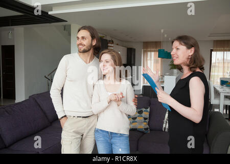 Realtor showing property for sale to young married couple Stock Photo