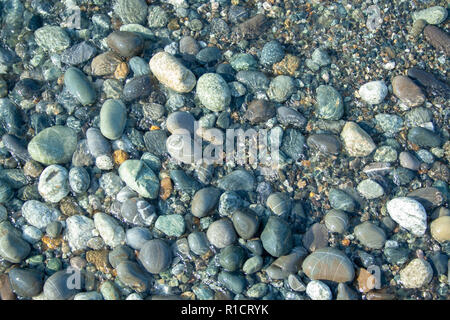 Stone beach with waves. Multi colore stones on beach Stock Photo