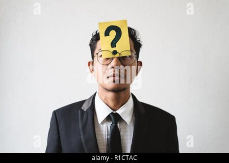 Young Asian businessman with QUESTION MARK on his forehead. Concept of business solution, planning and problems Stock Photo