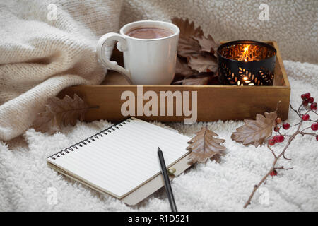 blank notebook with mug of coffee on warm cotton fabric Stock Photo