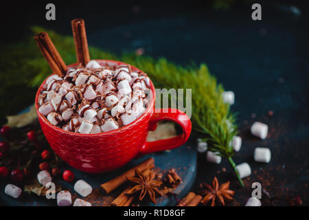 Christmas cocoa header with marshmallows, chocolate crumbs, and syrup. Large coffee cup with homemade hot chocolate. Winter drink photography on a dar Stock Photo