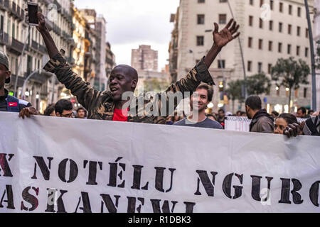 Barcelona, Catalonia, Spain. 11th Nov, 2018. A black man is seen raising his hands during the demonstration.A new manifestation against institutional racism has crossed the streets of the center of Barcelona. Accompanied by social organizations and the Trade Union of street vendors, more than 500 people have claimed to end racism in Barcelona and have denounced police identifications according to the color of their skin. Credit: Paco Freire/SOPA Images/ZUMA Wire/Alamy Live News