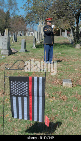 Washington, DC November 11, 2018: A bugler with the US Army Band, "Pershing's Own" plays "taps" while the US Gay and Straight Veterans and Active duty Service members attend a Veterans Day memorial observation at the tomb of Leonard Matlovich, a Gay soldier who fought the US Air Force which tried to remove his from service because he was gay. The tomb is located in the Congressional Cemetery in Washington DC. Patsy Lynch/MediaPunch Stock Photo