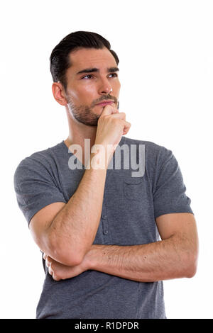 Studio shot of young handsome man thinking with hand on chin Stock Photo